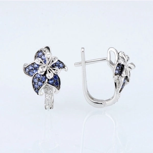 Floral mandala earrings in silver with blue and white stones on white background