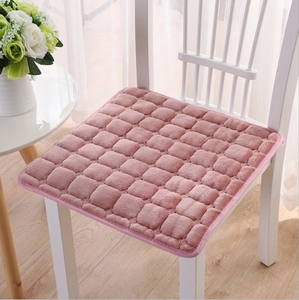 Plush pink flannel chair cushion with square texture on white chair in home setting
