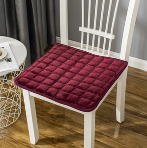 Quilted burgundy plush chair cushion detail with soft velvet texture on a wooden chair