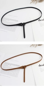 Detail view of knot-style slim PU leather belts in black and brown over minimalist background