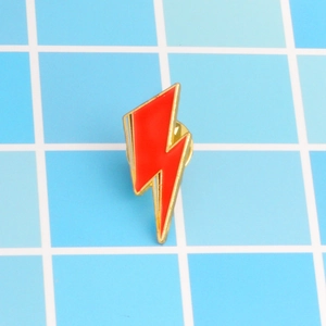 Creative red lightning bolt enamel brooch with gold metal trim on checkered background