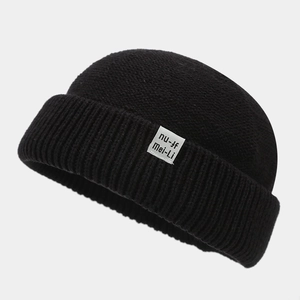 Detailed knit texture of a black vintage docker hat with white logo label on cuff