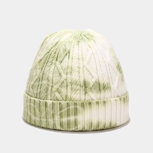 Detailed close-up of green and white tie-dye knit beanie showing ribbed texture and pattern