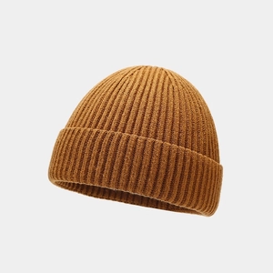 Close-up of caramel brown ribbed knit beanie showing high-quality fabric texture