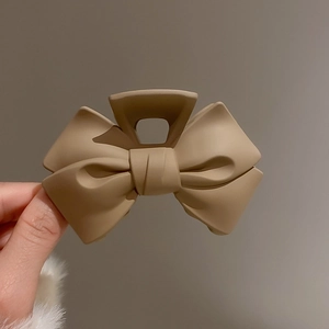 Detailed view of matte khaki bow hair claw clip with frosted texture and elegant design