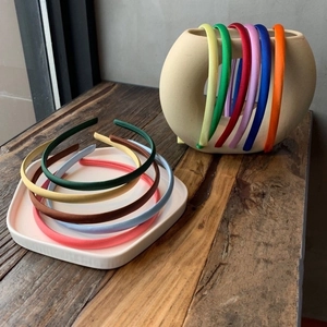 Slim satin headbands set in various jelly colors displayed on a white tray