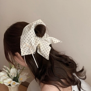 French style white hair scrunchie with black polka dots and large bow on model