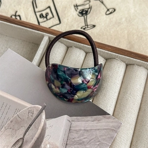Detail of a high-elastic hair tie featuring marble-textured acetate semicircle accessory