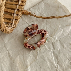 Detail of tortoiseshell resin hair claw with France Handmade stamp on creamy textured paper