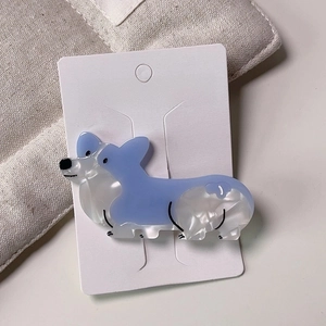 Macro detail of blue and white acetate Corgi dog hair clip with pearlescent finish