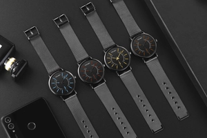 Detail of four quartz men's watches with black mesh bands in vibrant dial colors