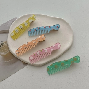 Set of five colorful floral resin hair combs in jelly style on a white stone tray
