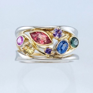 Macro detail of the colorful multi-gemstone ring with mixed gold and silver band