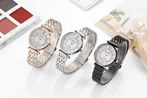 Close-up of stylish ladies' metal watches with mother-of-pearl dials and rhinestone bezels