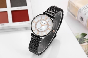 Close-up of black metal watch featuring a pearl dial with rose gold Roman numerals and crystals