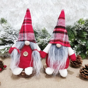Detail of couple Christmas gnomes with red plaid hats and grey beards on snow background