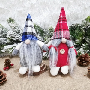 Nordic style Christmas gnomes with red and blue plaid hats and long beards on snow carpet