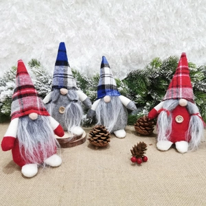 Set of four Nordic Christmas gnomes with plaid hats and long beards on festive table