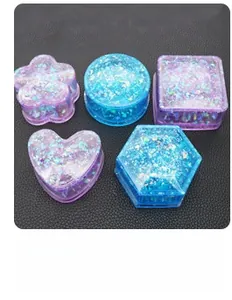 Macro shot of five geometric silicone molds for DIY resin crafts with purple glitter