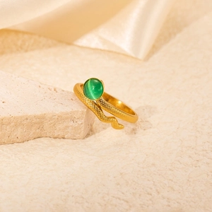 Detail of gold snake ring featuring scaled texture and a green cat eye stone setting