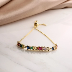 Dettaglio del bracciale regolabile placcato oro con pietre di zircone rettangolari colorate