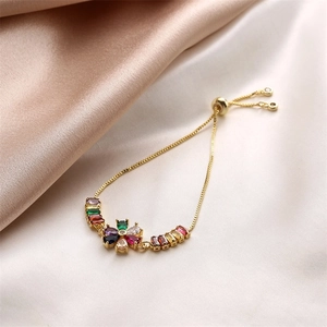 Dettaglio macro del bracciale farfalla in oro 18K con zirconi colorati su seta