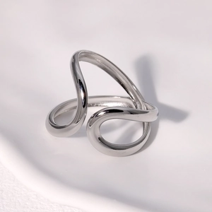 Close-up of a silver asymmetric geometric ring with wavy minimalist metal lines