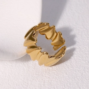 Macro shot of gold heart-shaped ring with polished finish and adjustable open band