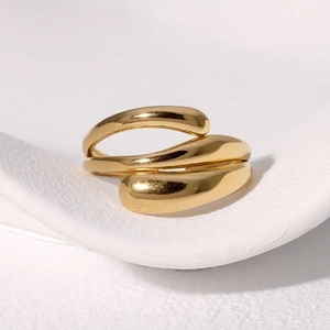 Detail of minimalist gold-plated multi-layer wrap ring with polished metallic finish