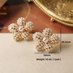 Macro shot of vintage pearl flower earrings with size specs and cream white texture