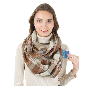 Detail of plaid faux cashmere scarf with integrated phone pocket in brown and beige