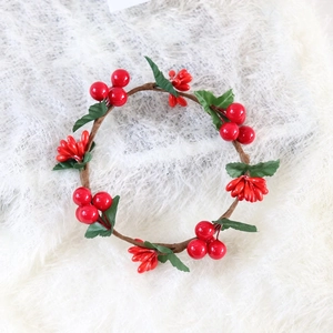 Detailed close-up of Christmas candle ring with red berries and green leaves on white fur