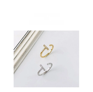 Detail of T-shaped open rings in gold and silver finish with pavé set cubic zirconia