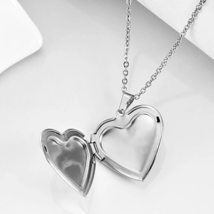 Polished silver locket necklace with open heart shape design for photos on white background