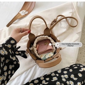 Interior view of brown woven bucket bag showing capacity for wallet and phone