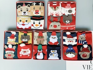 Detailed view of five red gift boxes containing cartoon Christmas cotton socks with festive patterns