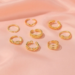 8-piece set of sexy carved gold toe rings with adjustable open bands on pink silk
