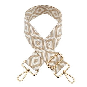 Detailed view of jacquard diamond pattern strap with golden metal swivel hooks and buckle