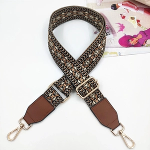 Close-up of ethnic embroidered jacquard strap with brown PU leather and gold metal hooks