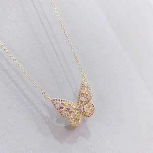 Macro shot of gold-plated hollow butterfly pendant necklace with purple zircon stones
