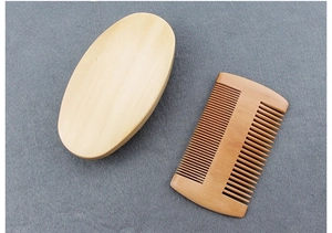 Close-up of wooden beard brush and double-sided comb set on a grey felt background