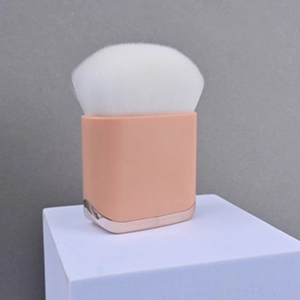 Detailed macro view of a pink square handle makeup brush with white flame-shaped bristles
