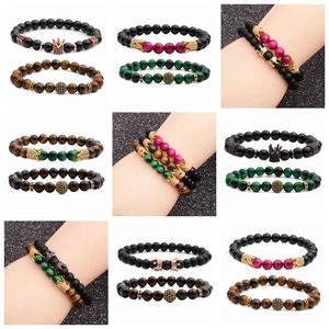 Close-up of 8mm tiger eye stone bracelets featuring metal crown charms and various beads