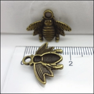 Macro view of vintage bronze bee pendant with textured wings and 2cm size scale