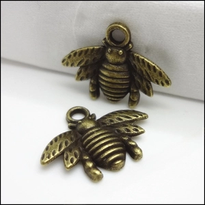 Macro detail of bee-shaped alloy pendant with vintage bronze finish and textured wings