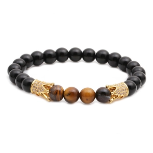 Tiger eye and obsidian beaded bracelet with two golden pavé crown charms on white background