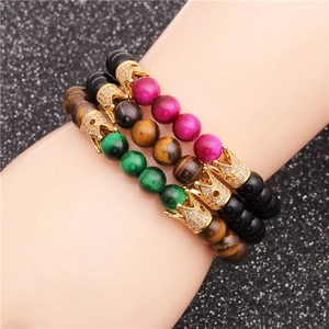Macro shot of tiger eye stone bead bracelets with sparkling crown charm accents