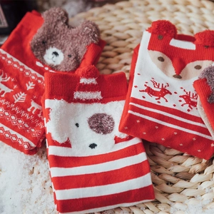 Three pairs of festive cotton Christmas socks with animal patterns in a holiday gift box