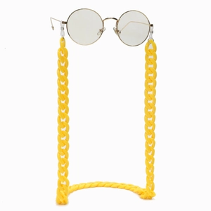 Detail of candy-colored acrylic eyeglass chain in bright yellow with gold round frame glasses