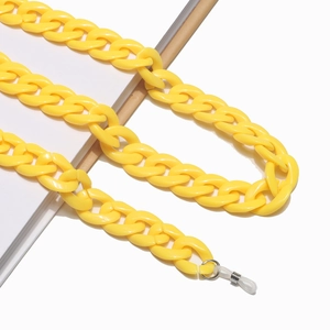 Detail of a bright yellow acrylic eyewear chain with silicone loops on white background